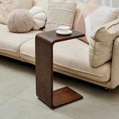 a coffee table sitting on top of a wooden stand in front of a white couch