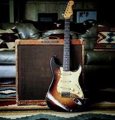 an electric guitar and amp sitting in front of a couch