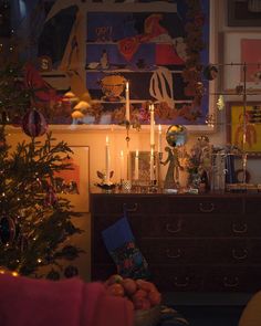 a living room with a christmas tree and decorations on the wall next to a dresser