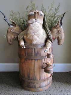 an image of a statue of santa claus in a barrel with birds on his head