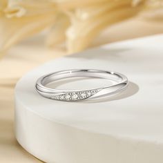 Simply and chic, this band is a clever accessory you will love. Featuring white stones, this band is an elegant symbol of your marital commitment. Buffed to a brilliant luster, this comfort-fit wedding band  will make your vows shine.Carat Weight: 0.086 ctStone Size: 1.1,1.3,1.5 mmStone Type: Jeulia® StoneNumber of Stones: 5 Stone Color: Diamond WhiteStone Shape: RoundWeight: 1.6 gWidth: 1.8 mmHeight: 1.8 mmThickness: 1.1 mmMaterial: 925 SilverPlating Color: Silver Elegant Stackable Diamond White Diamond Ring, Minimalist Half Eternity Band For Formal Occasions, Minimalist Formal Half Eternity Band, Elegant Stackable Diamond Bands, Elegant Stackable Diamond Ring, Elegant Stackable Eternity Band, Adjustable Diamond White Rings For Wedding, Adjustable Diamond White Wedding Rings, Minimalist Eternity Band For Formal Occasions