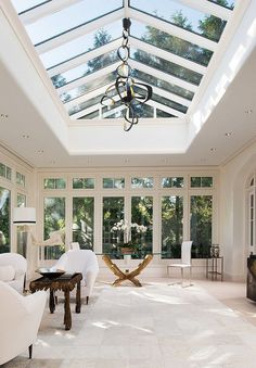 a living room filled with white furniture and lots of windows