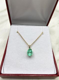 Displayed is a classic Colombian emerald solitaire necklace set in 14K yellow gold. This gorgeous solitaire pendant carries a full 1.50-carat emerald in a four-prong setting. Fully faceted, this gemstone showcases excellent shine. The emerald has excellent clarity with minor flaws that are normal in all genuine emeralds! This clarity is quite rare for an emerald with such a large size. The gem has a medium green color and excellent luster. An ideal solitaire, perfect for everyday use! 14K yellow Formal Pear-shaped Emerald Necklace In Fine Jewelry Style, Formal Pear-shaped Emerald Necklace Fine Jewelry, Formal Pear-shaped Emerald Necklace, Classic Diamond Cut Necklace For May Birthstone, Briolette Emerald Necklace For Formal Occasions, Formal Emerald Briolette Necklace, Formal Briolette Emerald Necklace, Classic Green Pear Shaped Necklace, Solitaire Gemstone Necklace For Formal Occasions