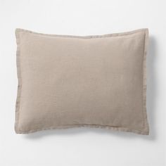 the linen pillow with ruffled edges is shown on a white wall and has a light brown