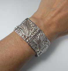 Here is an exceptional Art Nouveau completely handmade silver filigree bracelet circa 1890. The workmanship here is reminiscent of 18th century filigree in the quality and intricacy of this amazing piece. Each panel is entirely made by hand with silver wire twisted and wound into a fern and frond design each bouquet tied with a feminine bow. Amazingly each panel is not flat but the silver lace design is raised in relief with the central fern frond sitting higher to the rest of the panel. When th Wedding Filigree Bangle Bracelets, Victorian Etched Cuff Bracelet, Antique Cuff Bracelet With Intricate Design For Formal Occasions, Victorian Sterling Silver Bracelet, Engraved For Formal Occasions, Ornate Silver Hallmarked Bangle, Elegant Ceremonial Engraved Cuff Bracelet, Elegant Engraved Ceremonial Cuff Bracelet, Victorian Sterling Silver Engraved Wedding Bracelet, Elegant Engraved Cuff Bracelet For Ceremonial Occasions