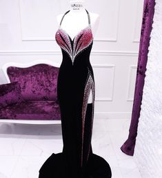 a black and white dress on display in front of a purple velvet couch with pink accents