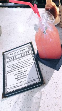 a pink drink sitting on top of a table next to a menu