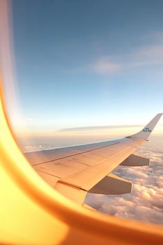 the wing of an airplane flying over clouds