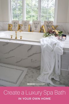 a bath tub sitting under a window next to a white towel and flowers in a vase