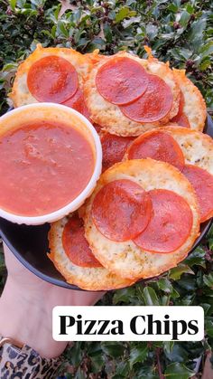 a person holding a plate full of pizza and dipping sauce