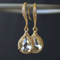 These beauties are standouts! Perfect for that special occasion! Elegant jeweled, french earrings carry stunning, teardrop crystals with a gold rope trim. The crystal detail on these earrings gives them such a classy and sophisticated feel. The last two pictures are for size reference. Details: * Gold-plated French Earrings * Faceted Crystal- 19 x 12mm(3/4x1/2") including rope trim * Length- 32mm(1 1/4") * Tarnish Resistant * Nickel and Lead-free These earrings come in an organza bag and gift box. Elegant Gold Teardrop Crystal Earrings, Gold Pear-shaped Earrings With Diamond Accents, Gold Teardrop Earrings With Diamond Accents For Wedding, Glamorous Gold Drop Bridal Earrings, Glamorous Gold Teardrop Earrings, Gold Pear-shaped Crystal Earrings, Elegant Gold Teardrop Earrings With Diamond Accents, Gold Pear-shaped Teardrop Earrings For Party, Gold Teardrop Bridal Earrings With Sparkles