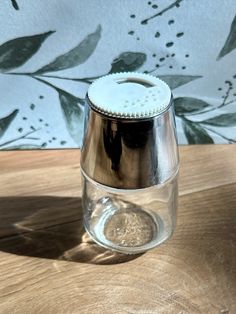 a glass jar sitting on top of a wooden table