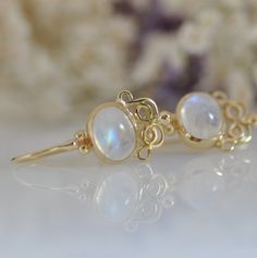 "These Moonstone gold dangle earrings are fine jewelry earrings, 14k solid gold and Moonstone gemstones. These earrings have an oriental style design. You will love the special color combination of the stone with the solid gold. The yellow gold and the white shades of the Moonstone are so beautiful together that you will want to look at all the time. The earrings can be made with other type of stones, every new combination is a surprise for me. You can ask me about different gemstone. Please loo 14k Yellow Gold Gemstone Earrings, Elegant 14k Gold Earrings With Gemstones, Elegant 14k Gold Gemstone Earrings, Fine Jewelry 14k Gold Filled Round Earrings, 14k Gold Filled Round Fine Jewelry Earrings, Handmade Moonstone Jewelry In Yellow Gold, Handmade Yellow Gold Moonstone Jewelry, Delicate Sterling Silver Yellow Gold Earrings, Delicate 14k Gold Round Earrings