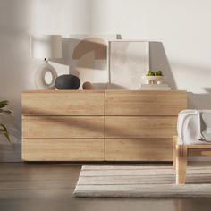 a room with a wooden dresser and white rug