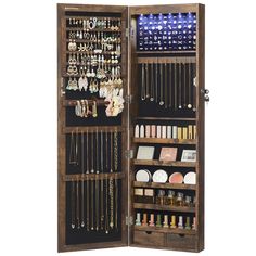 an open wooden jewelry cabinet filled with lots of necklaces