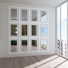 an empty room with many windows on the wall and wood flooring in front of it