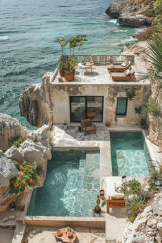 an aerial view of a house with a swimming pool and patio area next to the ocean