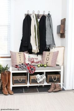 a coat rack filled with coats and pillows