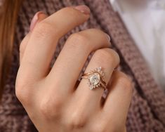 a close up of a person wearing a ring on their finger and holding the other hand