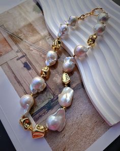 "This flashy necklace features a gold plated rhinestone sun and many natural sparkly Baroque Pearl.The golden stone is tarnish resistant gold plated.Handmade in Vancouver. 🤍Material🤍 40cm length baroque Pearl size:15-18mm Golden stone:16mm-22mm 14K Gold Plated PLEASE NOTE  Due to the natural culturing process each pearl is shaped differently and colors vary,which adds uniqueness to your necklace. Feel free to message me if you have any questions😊 CARE&INFO Give your jewelry a little TLC to keep your jewelry shining bright. Remove body oils, perfumes and lotions with a soft lint-free jewelry cloth that over time will prevent damage to the finish on your beautiful Frons.L jewelry. TOP TIPS Avoid the S's - Sleep, Shower, Swim, Sprays (perfumes) & Sweat (exercise) Fasten up your necklaces a Luxury Gold Pearl Necklaces, Gold Pearl Necklace With Jewels, Unique Handmade Gold Pearl Necklace, Gold Round Necklace With Jewels, Unique Gold Pearl Jewelry, Unique Gold Necklace With Baroque Pearl, Gold Pearl Necklace With Jewels As A Gift, Unique Gold Baroque Pearl Necklaces, Gold Plated Pearl Jewelry