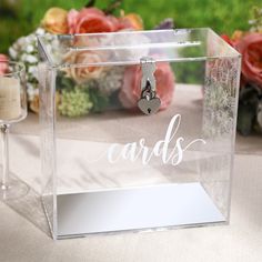 a clear acrylic box with the word cards on it and a wine glass next to it