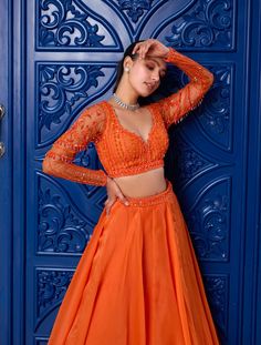 Radiate warmth and elegance in this orange hand-embroidered tonal blouse! Intricately embellished with sequins, glass beads, and stones, it adds a touch of opulence to your ensemble. Paired with a flowy silk organza skirt featuring a soft can-can, it offers a graceful silhouette. Complete your look with a net dupatta adorned with diagonal lines embroidery, adding a dash of sophistication. Embrace timeless charm with this captivating attire, perfect for making a statement at any special occasion. Orange Georgette Sets For Reception, Festive Orange Set With Sheer Dupatta, Festive Orange Georgette Set, Designer Orange Silk Lehenga, Orange Silk Lehenga For Designer Wear, Designer Wear Orange Silk Lehenga, Evening Organza Blouse With Sheer Dupatta, Evening Blouse With Sheer Dupatta In Organza, Orange Georgette Choli For Reception