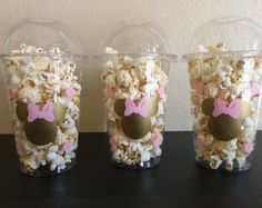 three plastic cups filled with popcorn and minnie mouse ears