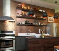 a kitchen with stainless steel appliances and wooden cabinets, along with shelves filled with dishes