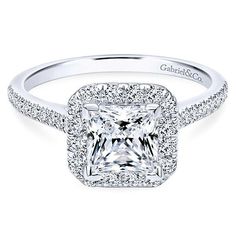 an engagement ring with a princess cut diamond surrounded by pave diamonds on the sides