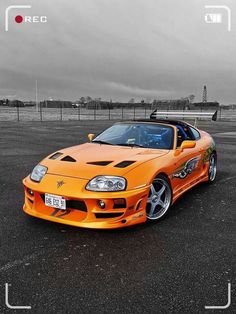 an orange sports car parked in a parking lot