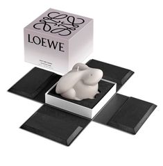 an elephant figurine sitting in a box on top of two black coasters