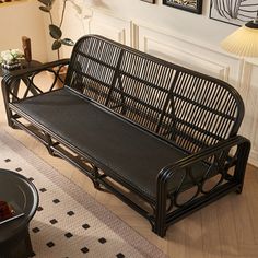 a black metal bench sitting on top of a hard wood floor next to a table