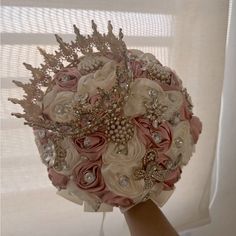 a bridal bouquet with brooches and flowers in front of a window sill