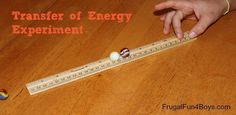 a child is playing with a ruler and magnets on the wooden floor that says, transfer of energy experiment