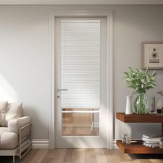 a living room with white walls and wooden flooring next to a window covered in blinds