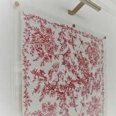 a red and white wall hanging on the side of a building