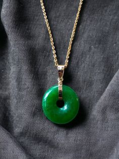 An 18mm, bigger version of our classical Jade Disc Pendant. Perfect as a statement piece; we use a simple Jadeite Donut with a gold hook to finish the simple yet elegant look. This evergreen design pairs well in formal and everyday settings alike. The green Jade with the centric hole allows light to pass through creating a focused optical effect. (Gold chain not included) Stock ID: 1JTDP14Y Materials: 0.30g 14K Gold, 1.9g Jadeite Dimensions: 25 x 18 x 3 mm Gross Weight: 2.20g Elephant Pendant, Disc Pendant, Jade Pendant, Unique Pendant, Jade Green, Gold Chains, Handcrafted Jewelry, Jade, Jewelry Crafts