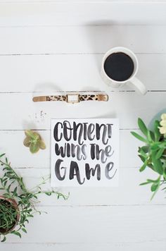 a cup of coffee sitting on top of a table next to a sign that says, comen't miss the game