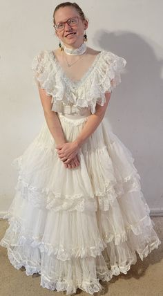 This was my mother's wedding dress when she married my father in 1984.  It's "virgin white" and very frothy and cupcakey.  It is meant to have a hoop skirt underneath, hence the layers. My model is 5'4" barefoot.  She is a size 4. Also comes with a halo headpiece with trailing veil. Please feel free to message me with any questions! Wedding Dress With Hoop Skirt, Gender Neutral Wedding Attire, Barefoot Wedding Dress, Oaxaca Wedding Dress, Puffy Dress Aesthetic, Rock And Roll Wedding Dress, Plus Size Vintage Wedding Dress, Ugly Wedding Dress Funny, Bad Wedding Dresses