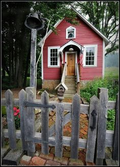 a small red house with a wooden fence