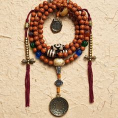 Experience the wisdom of Yama principles and tap into the transformative energy of 108 Bodhi Seed and Tibetan Agate Mala Beads. Explore ancient teachings and wear the lovely Tibetan Agate beads to find inner peace and harmony on your spiritual path. · Material: Bodhi Seed· Yama Pendant: White Copper· Tibetan Astrology Pendant: Brass· Thread: Cotton· Size: 8mm· Process: Handmade (Up to three days) Five- Eyed Bodhi Seed Tibetan Agate Yak Horn Lamp work glass additions The Bell and Dorje Amulets ar Holistic Wooden Beaded Bracelets For Meditation, Agate Beaded Bracelets With 108 Beads For Meditation, Spiritual Wooden Beads Mala For Festival, Adjustable Amulet Mala For Rituals, Holistic Mala With 108 Beads For Festival, Bohemian Wooden Beads Mala For Festival, Bohemian Festival Mala With Wooden Beads, Handmade Amulet Mala For Meditation, Beaded Amulet Mala For Meditation