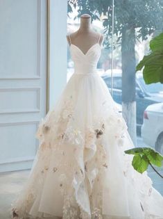 a wedding dress on display in front of a window