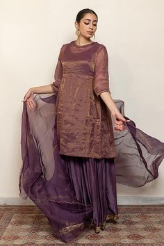 Aubergine kurta with embroidered floral and half moon motifs. Comes with an inner, matching gharara and an organza silk dupatta.
Components: 4
Pattern: Embroidered
Type Of Work: Thread, Sequin
Neckline: Round
Sleeve Type: Three quarter
Fabric: Kurta: Chanderi Tissue, Gharara: Cotton Silk, Dupatta: Organza silk, Lining: Cotton
Color: Purple
Other Details: 
Straight silhouette
Kurta side gathers
Occasion: Sangeet,Mehendi and Haldi - Aza Fashions Navratri Purple Palazzo Set With Cutdana, Purple Palazzo Set With Sheer Dupatta For Diwali, Purple Silk Bollywood Palazzo Set, Purple Anarkali Palazzo Set With Cutdana, Purple Silk Sharara For Navratri, Elegant Purple Chanderi Palazzo Set, Designer Purple Chanderi Palazzo Set, Purple Silk Palazzo Set With Straight Kurta, Festive Purple Palazzo Set With Pallu