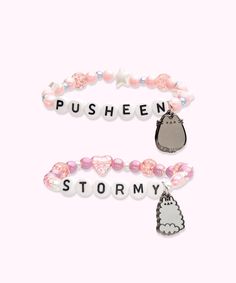 Front view of the Pusheen and Stormy Best Friends Bracelet Set. One of the bracelets has light pink round beads in varying sizes paired with white stars and silver beads with the letters “PUSHEEN” spelled out in beads in the middle and a dangle charm of Pusheen the Cat. The second bracelet has a dangle charm of Little Sister Stormy with purple round beads, pink heart beads, and white small beads. In the middle of the second bracelet is “STORMY” spelled out in letter beads. Pusheen Gifts, Bestie Bracelets, Pusheen Stormy, Pusheen Shop, Friends Bracelet, Diy Kandi Bracelets, Diy Kandi, Cat Bracelet, Playful Style