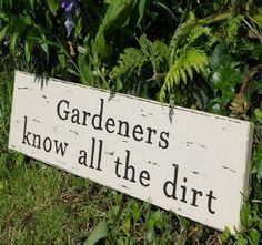 a sign that says gardener's know all the dirt is in front of some bushes