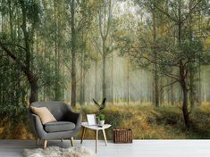 a chair and table in front of a forest wall mural