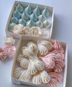 two white boxes filled with different colored seashells