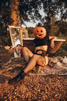 a woman sitting on the ground with a pumpkin in her head and wearing tights