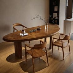 a wooden table with chairs around it and a vase on the table next to it