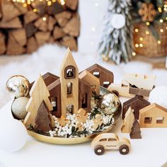 small wooden houses and christmas decorations on a table